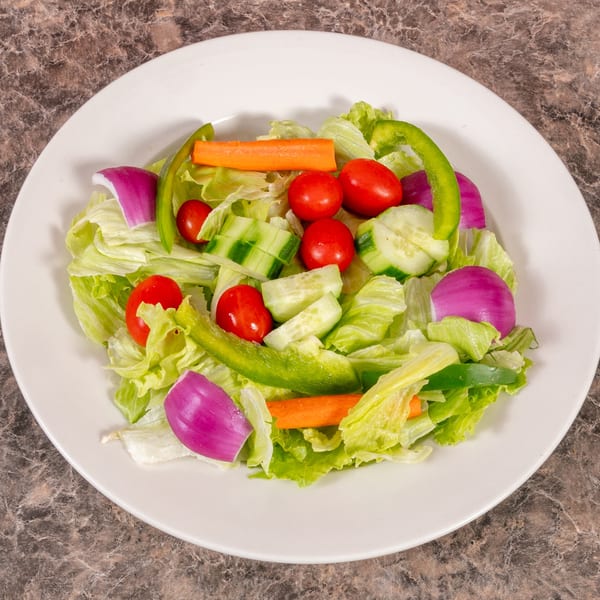 Fresh garden salad with lettuce, tomatoes, cucumbers, carrots, red onion, and green bell pepper.