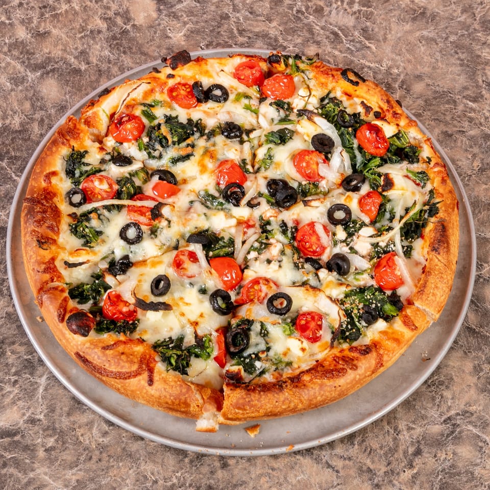 Mr. G's Pizzeria's whole pizza with spinach, cherry tomatoes, black olives, and onions.